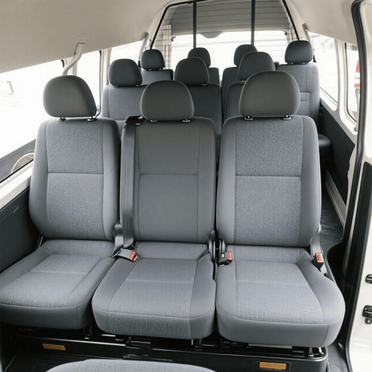 Auckland Airport Van Transfer 5 Toyota Hiace 12-seater van - real photos you provided. Left: High-roof cabin interior with 11 grey passenger seats. Right: Massive open boot at Auckland Airport Terminal 3 loaded with 10+ suitcases, golf bags (Callaway & Titleist), stroller and luggage.
